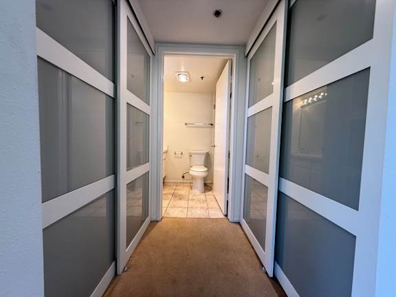 A bathroom with a toilet and sink is visible through a doorway.