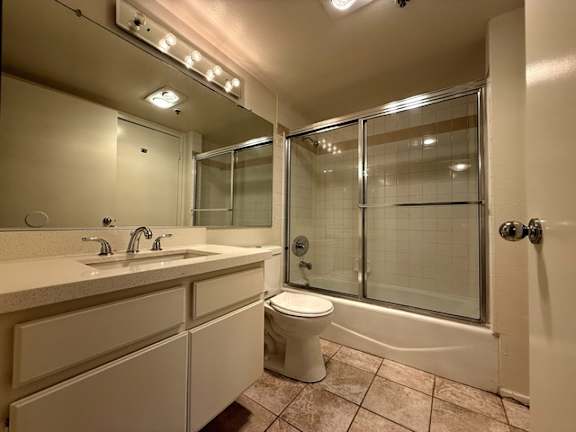 A bathroom with a toilet, sink, and shower.