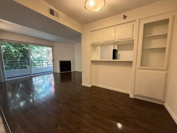 A room with white cabinets and a black speaker.