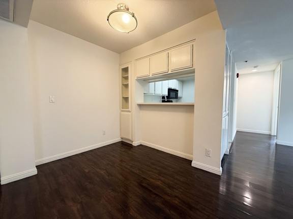 A room with a wooden floor and a white wall.
