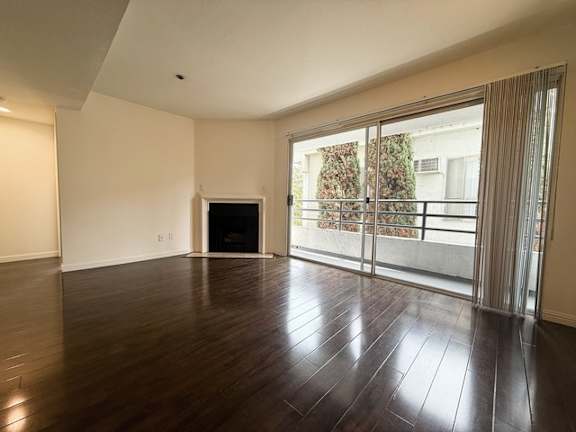 A spacious room with a fireplace and sliding glass doors.