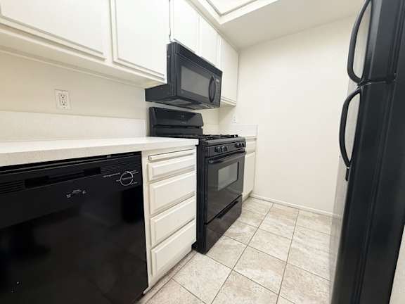 A black oven is on the left side of a white countertop.