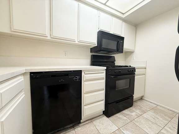 A black microwave is on top of a black oven.