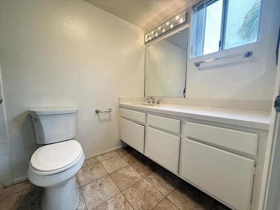 A white toilet and sink in a small bathroom.