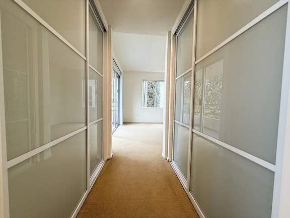 A long hallway with glass walls on both sides.