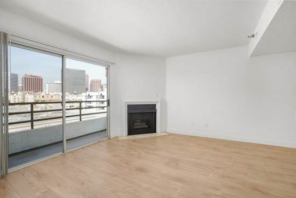 A room with a fireplace and a view of the city.