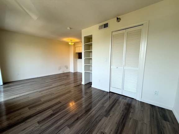 A room with wooden flooring and a white door.