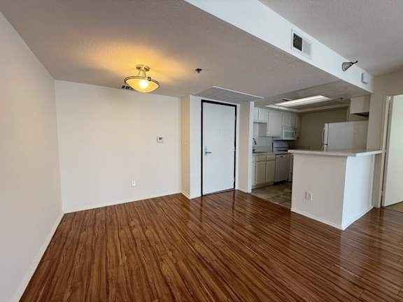 A room with wooden floors and a ceiling light.