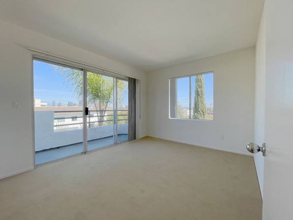 A room with a sliding glass door leading to a balcony.