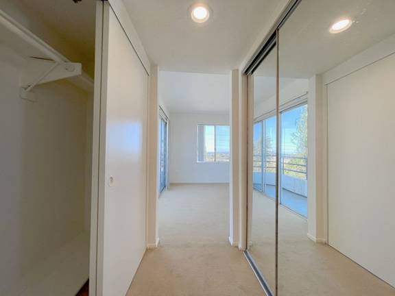 A hallway with white walls and a carpeted floor.