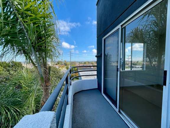 A balcony with a view of the sky and vegetation.