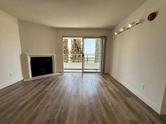 A room with a fireplace and sliding glass doors.