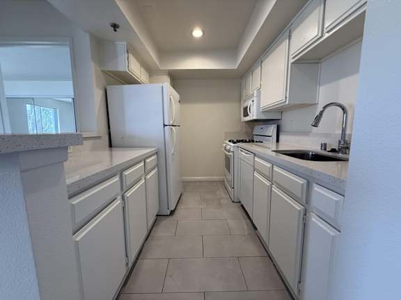 A kitchen with white appliances and cabinets.