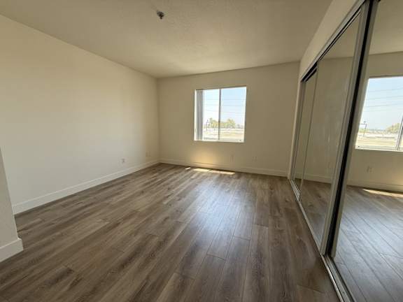 A room with wooden flooring and a window.