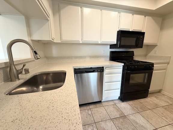 A kitchen with a black oven and a black microwave.