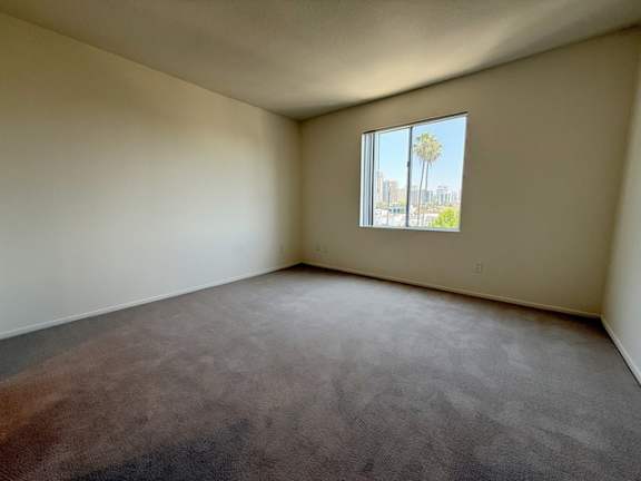 Empty room with a window showing a cityscape outside.
