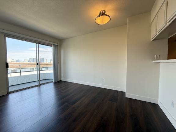 A room with a sliding glass door leading to a balcony.