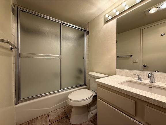 A bathroom with a toilet, sink, and shower.