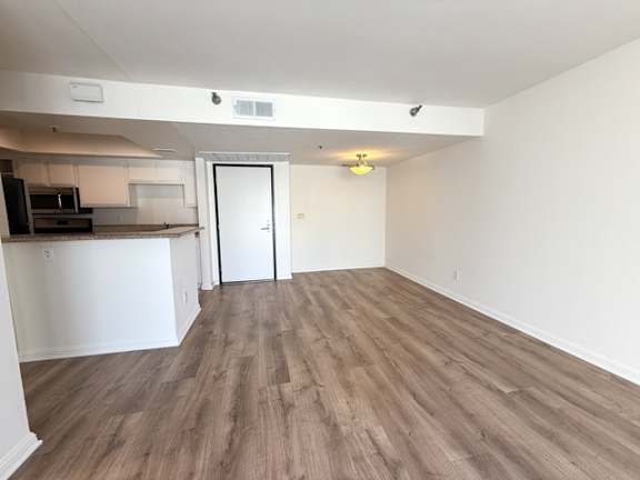 A room with a white door and a wooden floor.