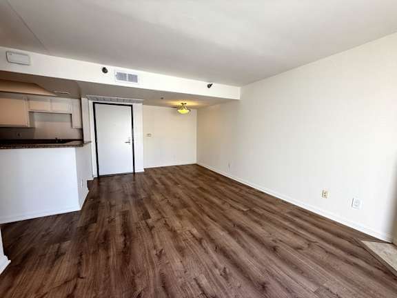 A room with wooden flooring and a white door.