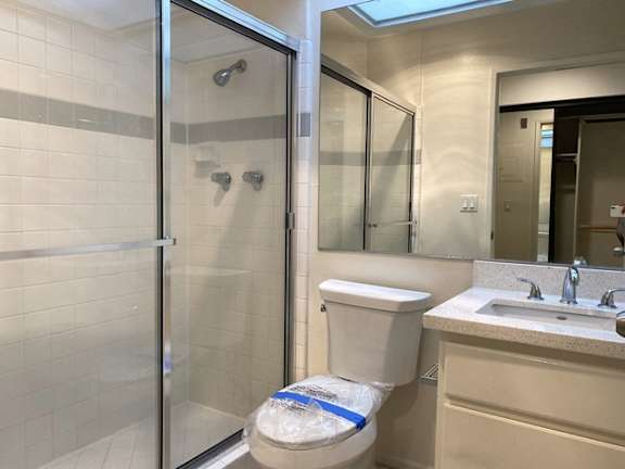 A bathroom with a toilet, sink, and shower.