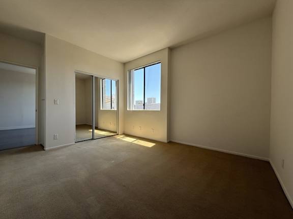 A room with a carpeted floor and a window.