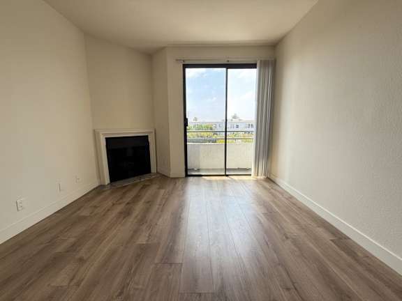 A room with a fireplace and sliding glass doors leading to a balcony.