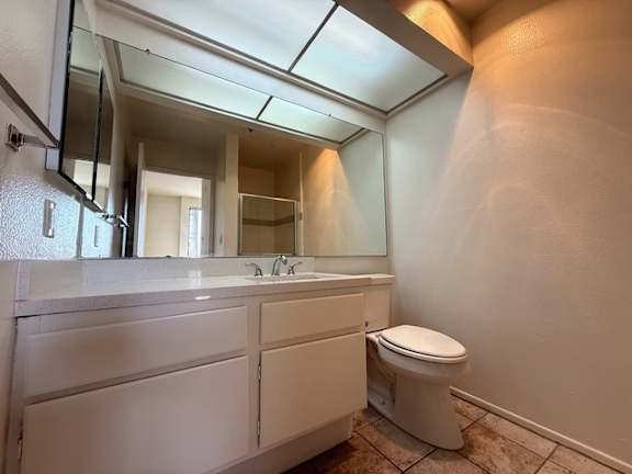 A bathroom with a toilet, sink, and mirror.