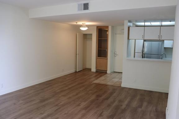 A room with wooden flooring and a doorway leading to another room.