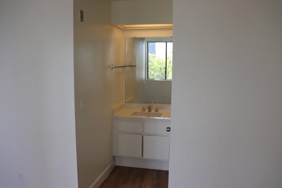 A small white bathroom with a sink and mirror.