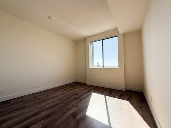 A room with a window and wooden flooring.