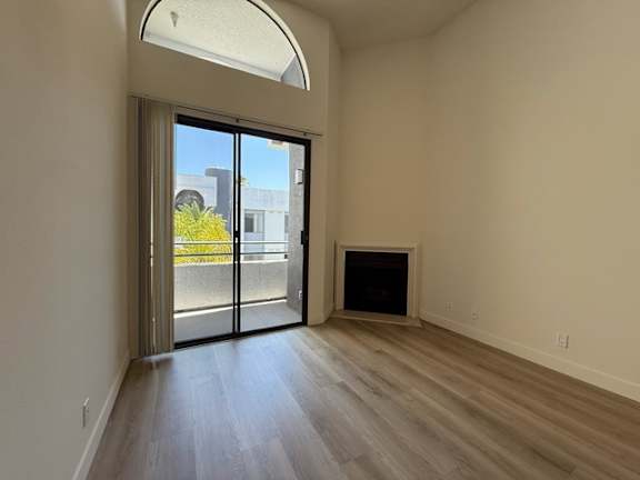 A room with a sliding glass door leading to a balcony.
