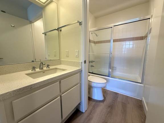 A white toilet is in a bathroom with a walk-in shower.