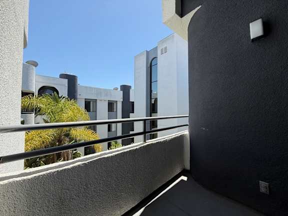 A modern building with a balcony and a metal railing.