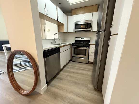A modern kitchen with stainless steel appliances and white cabinets.