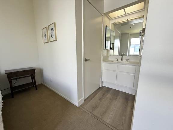 A bathroom with a mirror, sink, and a wooden table.
