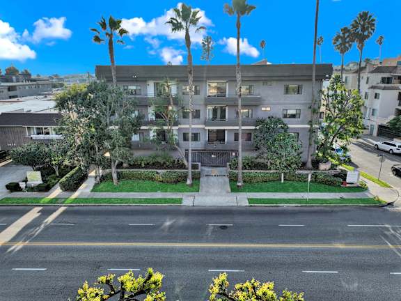 A building with a green lawn in front and a street in front of it.