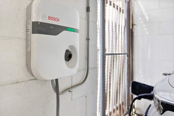 A Bosch electric vehicle charging station is mounted on a wall.