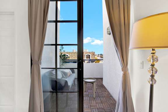 A room with a view of the city through a large window.