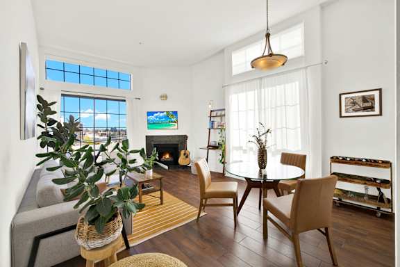 A living room with a fireplace and a TV on the wall.