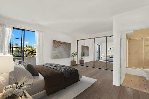 A bedroom with a large bed and a view of the outdoors through a window.