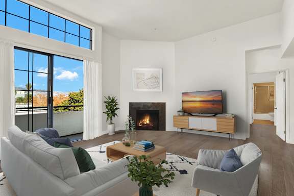A modern living room with a fireplace and a large window.