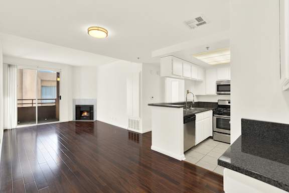 A modern kitchen with white cabinets and a black countertop.