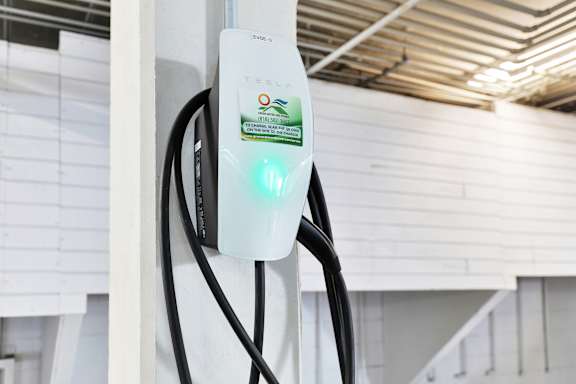 A Tesla charging station is plugged into a wall socket.