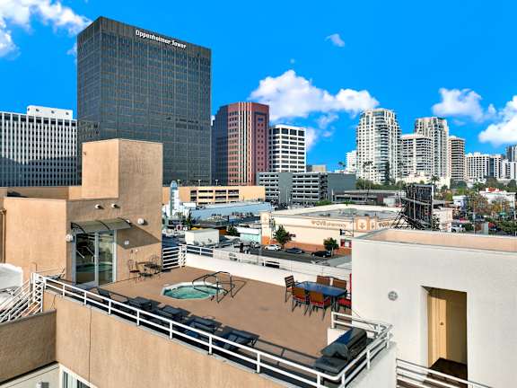 A view of a cityscape with a pool on the balcony of a building.