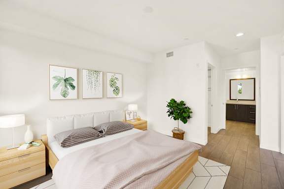 A bedroom with a bed, nightstand, and a plant.
