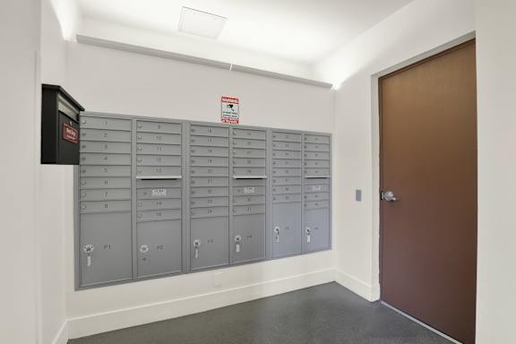 A row of mailboxes are lined up against a wall.
