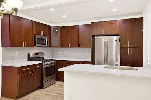 A kitchen with brown cabinets and a white counter.