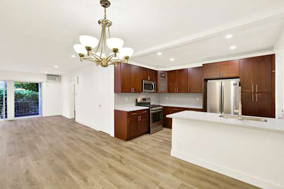 A modern kitchen with wooden cabinets and a white island.