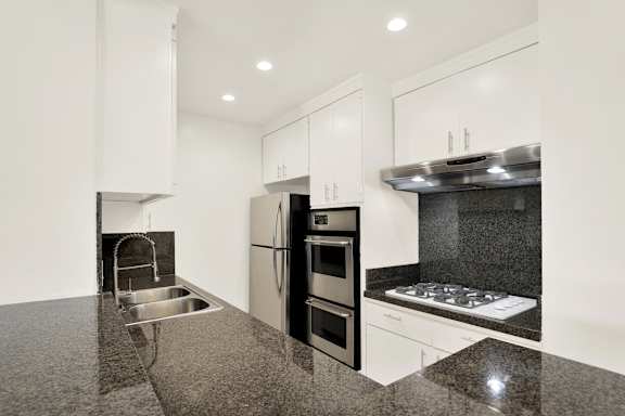A modern kitchen with granite countertops and stainless steel appliances.